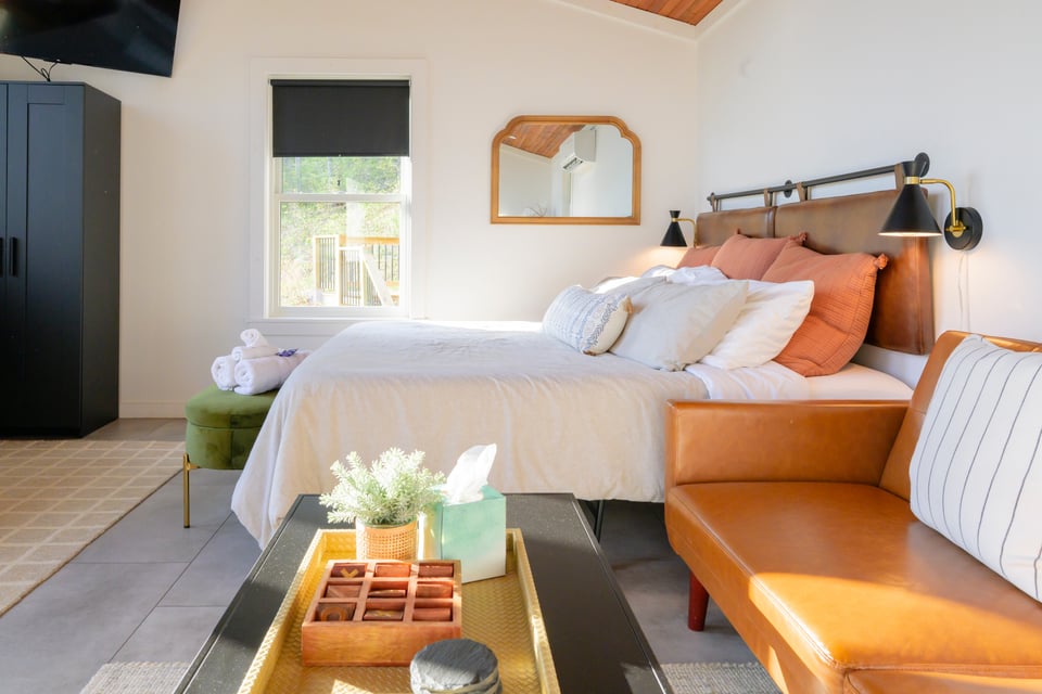 King bedroom with cognac leather headboard, terracotta pillows and cedar ceiling